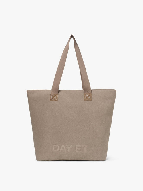 Shopperveske i lys, varm gråbeige filtaktig tekstil med lange skulderstropper i vevd bånd og preget DAY ET-logo, sett forfra.