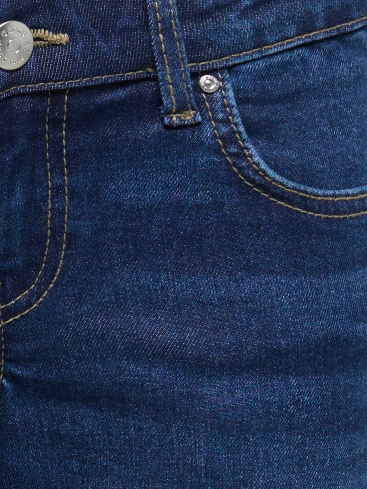 Nærbilde av mørkeblå denim med kontrastsøm, lomme og metallknapp
