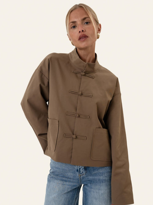 Eva jakke dark brown - forfra på modell, mandarinkrave og knutelukninger